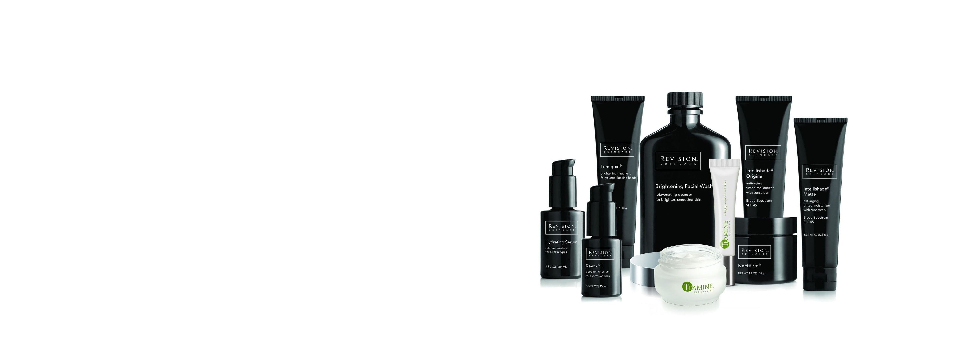 A collection of skincare products from Revision Skincare with black and white packaging, including bottles, tubes, and jars, displayed in a group on a white background.