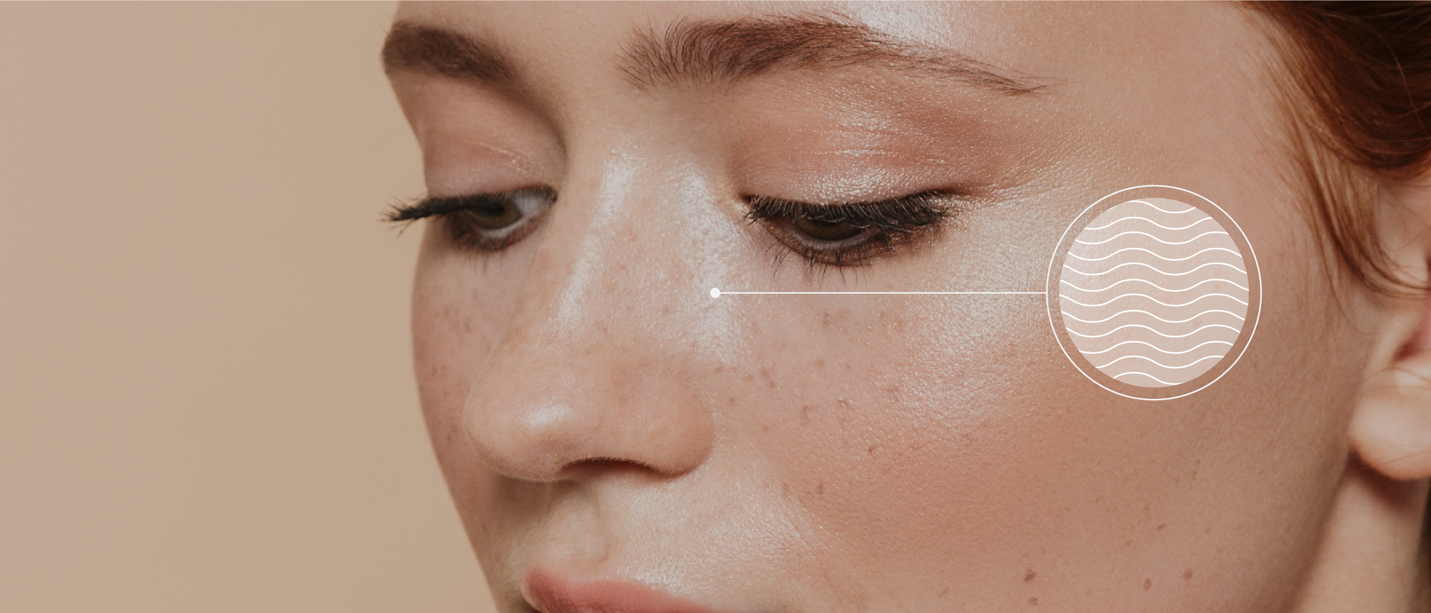 Close-up of a womans face with freckles, showing a cheek with glowing skin. An illustration of wavy lines in a circle highlights the cheek area, suggesting an oily skin texture. The background is a neutral tone.